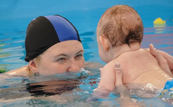 Женщина Мать и ребенок в бассейне. Первый раз плавание. Стоковое Фото