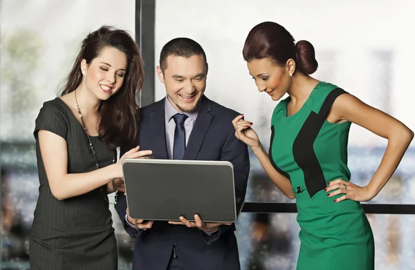 Tres personas de oficina mirando la computadora y riendo — Foto de Stock