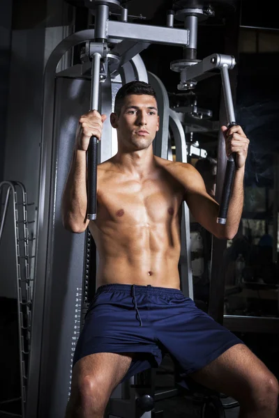 Hombre musculoso haciendo ejercicio con pec deck en el gimnasio — Foto de Stock