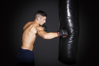 kaslı adam spor salonunda boks torbası ile eğitim