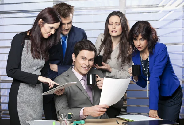 Bedrijfsleider omringd door toegewijd team — Stockfoto