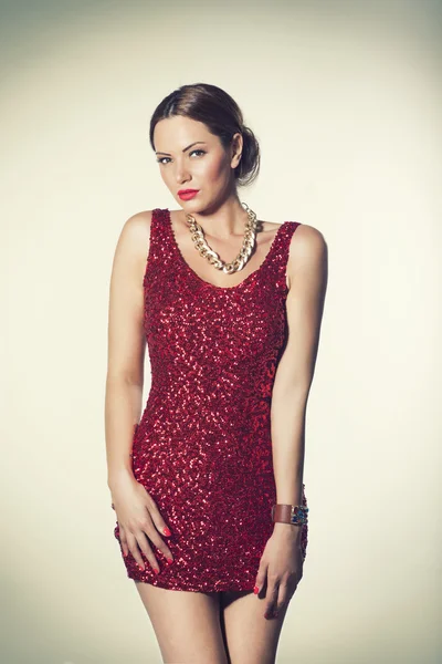 Modeporträt einer Frau im rot glänzenden kurzen Kleid — Stockfoto
