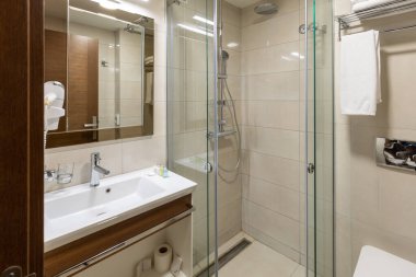 Cam duş kabini olan bir otel banyosu.