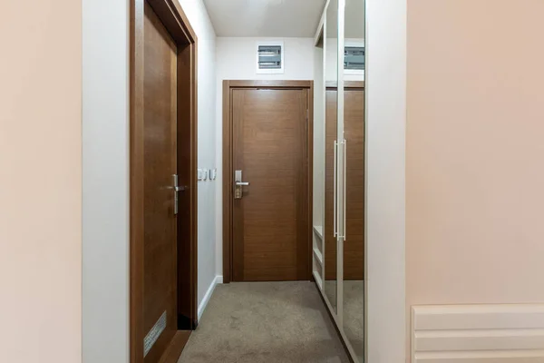 茶色の木製のドアとカーペット状のホテルの廊下の戸口のインテリア — ストック写真