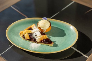 Vanilyalı dondurmayla servis edilen vişneli turta