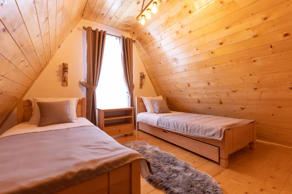 Interior of a wooden mountain house attic two bed bedroom