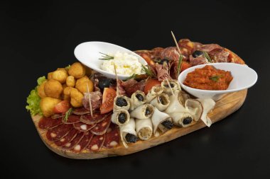 Antipasti ahşap bir tahtada servis edilir.