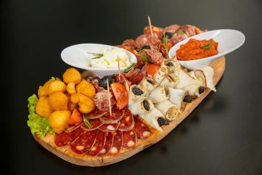 Antipasti ahşap bir tahtada servis edilir.