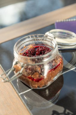 Kavanozda servis edilen meyveli müsli.