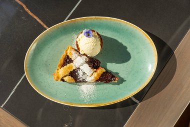 Vanilyalı dondurmayla servis edilen vişneli turta