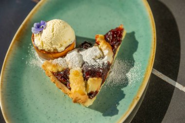 Vanilyalı dondurmayla servis edilen vişneli turta