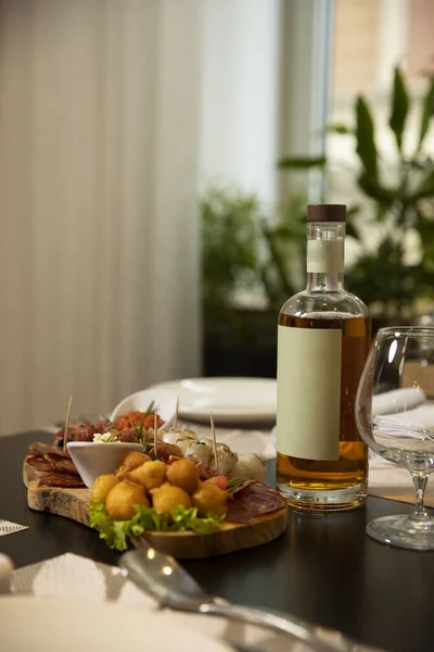 ウィスキーのモックアップボトルはレストランのテーブルの上で食べ物を提供します — ストック写真
