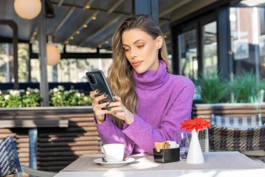 Kafe barında yalnız mesajlaşan güzel bir kadın.