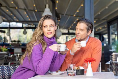 Sabahları kafede kahve içen mutlu bir çift.