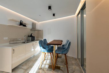 Sabahları yemek masası ve sandalyeleri olan modern bir mutfak.