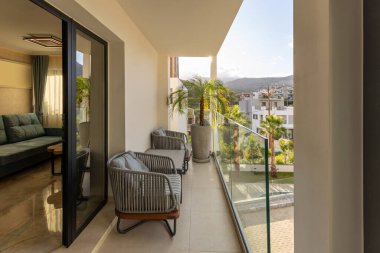 Çiçekleri ve cam çitleri olan bir otel terası.