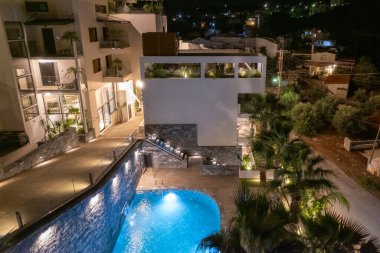 Gece vakti bir otelin yüzme havuzunun üstünde.