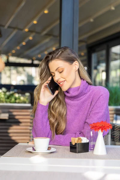 Kafe barında akıllı telefonunu kullanan güzel bir kadın