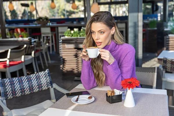 Harika bir kadın kafe barında kahve içiyor.