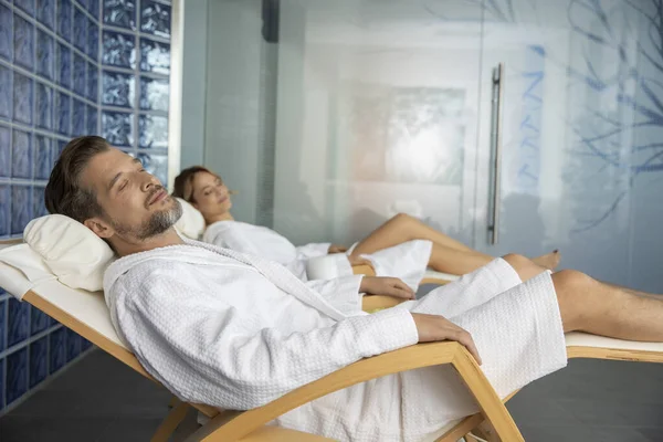 Couple Wearing Bathrobe Relaxing Wellness Center Sleeping – stockfoto