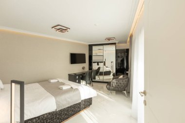 Lüks bir çift kişilik otel odasının içinde siyah beyaz mobilyalar var.