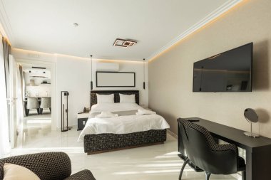 Lüks bir çift kişilik otel odasının içinde siyah beyaz mobilyalar var.