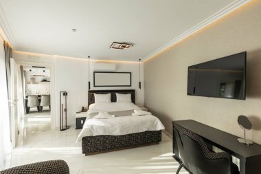 Lüks bir çift kişilik otel odasının içinde siyah beyaz mobilyalar var.