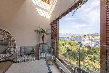 Otel tatil köyü terasları koltuk, masa ve sallanan yumurta koltukları.