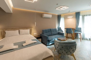 Lüks bir çift kişilik otel odasının içinde siyah beyaz mobilyalar var.