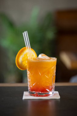 Bardakta buz küpleriyle sıkılmış portakal suyu.