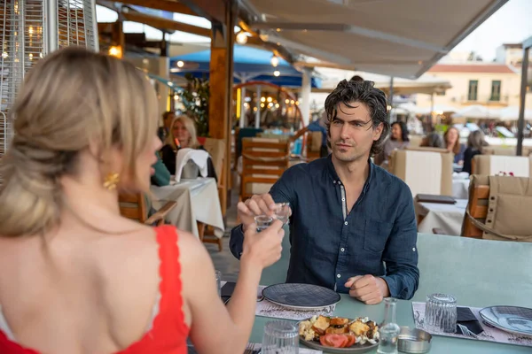 Romantic couple toasting in the garden restaurant by the sea