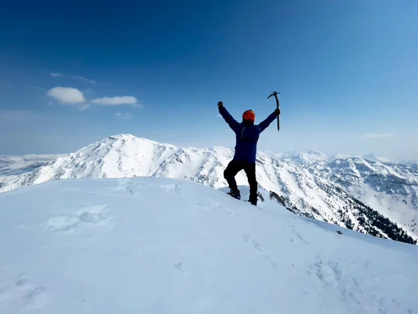成功的登山者单人登顶远足和令人赞叹的冬季景色 图库图片