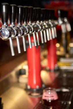Barmen tezgahın önünde bira dolduruyor. Müşteri için büyük boy bira dolduruyorum..