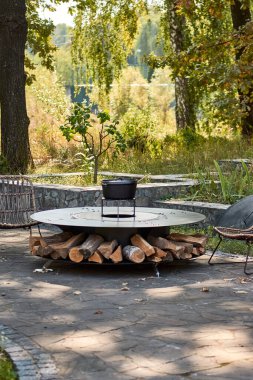Tencere dibin kara seninki benden kara, seninki benden kara. Yuvarlak masa pişirme yüzeyi. Arka bahçede sıcak barbekü