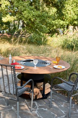 Tencere dibin kara seninki benden kara, seninki benden kara. Yuvarlak masa pişirme yüzeyi. Arka bahçede sıcak barbekü