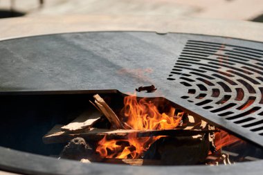 Tencere dibin kara seninki benden kara, seninki benden kara. Yuvarlak masa pişirme yüzeyi. Arka bahçede paslanmaz çelik ızgaralı barbekü ızgarası hazır ızgara yemeği. İçinde alevler olan ızgara..