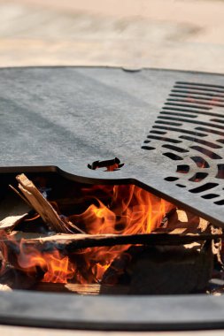 Tencere dibin kara seninki benden kara, seninki benden kara. Yuvarlak masa pişirme yüzeyi. Arka bahçede paslanmaz çelik ızgaralı barbekü ızgarası hazır ızgara yemeği. İçinde alevler olan ızgara..