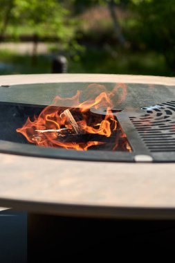 Tencere dibin kara seninki benden kara, seninki benden kara. Yuvarlak masa pişirme yüzeyi. Arka bahçede paslanmaz çelik ızgaralı barbekü ızgarası hazır ızgara yemeği. İçinde alevler olan ızgara..