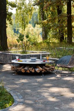 Demir Şebeke 'li Kettle Grill Pit. Yakacak odunlu yuvarlak masa pişirme yüzeyi. Arka bahçede paslanmaz çelik ızgaralı barbekü ızgarası hazır ızgara yemeği. İçinde alevler olan ızgara..