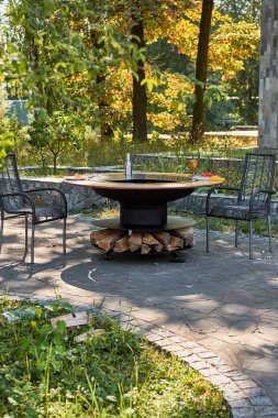 Demir Şebeke 'li Kettle Grill Pit. Yakacak odunlu yuvarlak masa pişirme yüzeyi. Arka bahçede paslanmaz çelik ızgaralı barbekü ızgarası hazır ızgara yemeği. İçinde alevler olan ızgara..