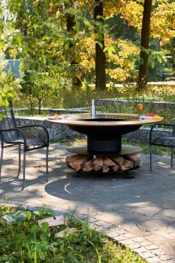 Demir Şebeke 'li Kettle Grill Pit. Yakacak odunlu yuvarlak masa pişirme yüzeyi. Arka bahçede paslanmaz çelik ızgaralı barbekü ızgarası hazır ızgara yemeği. İçinde alevler olan ızgara..