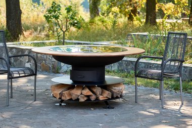 Demir Şebeke 'li Kettle Grill Pit. Yakacak odunlu yuvarlak masa pişirme yüzeyi. Arka bahçede paslanmaz çelik ızgaralı barbekü ızgarası hazır ızgara yemeği. İçinde alevler olan ızgara..