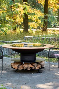 Demir Şebeke 'li Kettle Grill Pit. Yakacak odunlu yuvarlak masa pişirme yüzeyi. Arka bahçede paslanmaz çelik ızgaralı barbekü ızgarası hazır ızgara yemeği. İçinde alevler olan ızgara..