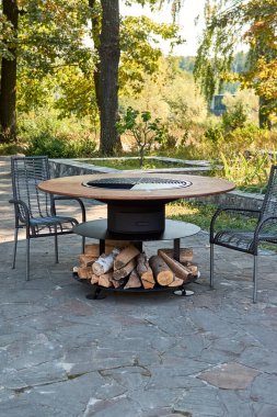 Demir Şebeke 'li Kettle Grill Pit. Yakacak odunlu yuvarlak masa pişirme yüzeyi. Arka bahçede paslanmaz çelik ızgaralı barbekü ızgarası hazır ızgara yemeği. İçinde alevler olan ızgara..