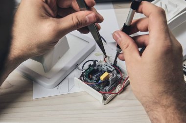 Elektronik cihazların tamiri, kalay lehimleme parçaları. Tornavida tutan adamın elleri. Bilgisayar devre kartı.