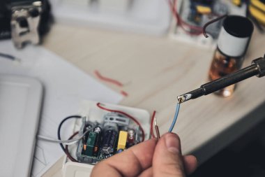 Elektronik cihazların tamiri, kalay lehimleme parçaları. Tornavida tutan adamın elleri. Bilgisayar devre kartı.