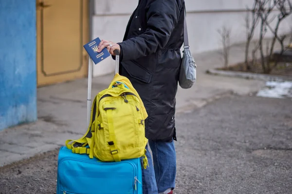 Evacuation of civilians, sad child holding a passport with yellow-blue flag. Stop war