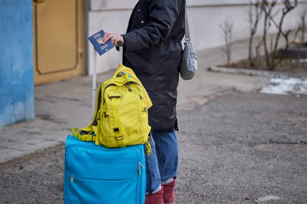 Evacuation of civilians, sad child holding a passport with yellow-blue flag. Stop war