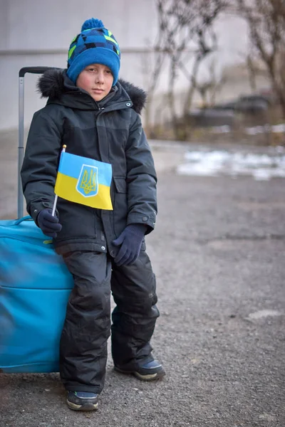 Ewakuacja cywilów, smutne dziecko z paszportem z żółto-niebieską flagą. Przerwać wojnę. — Zdjęcie stockowe