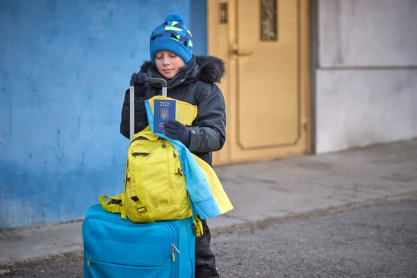Евакуація цивільних осіб, сумна дитина, що тримає паспорт з жовто-блакитним прапором. Зупинити війну Стокове Зображення